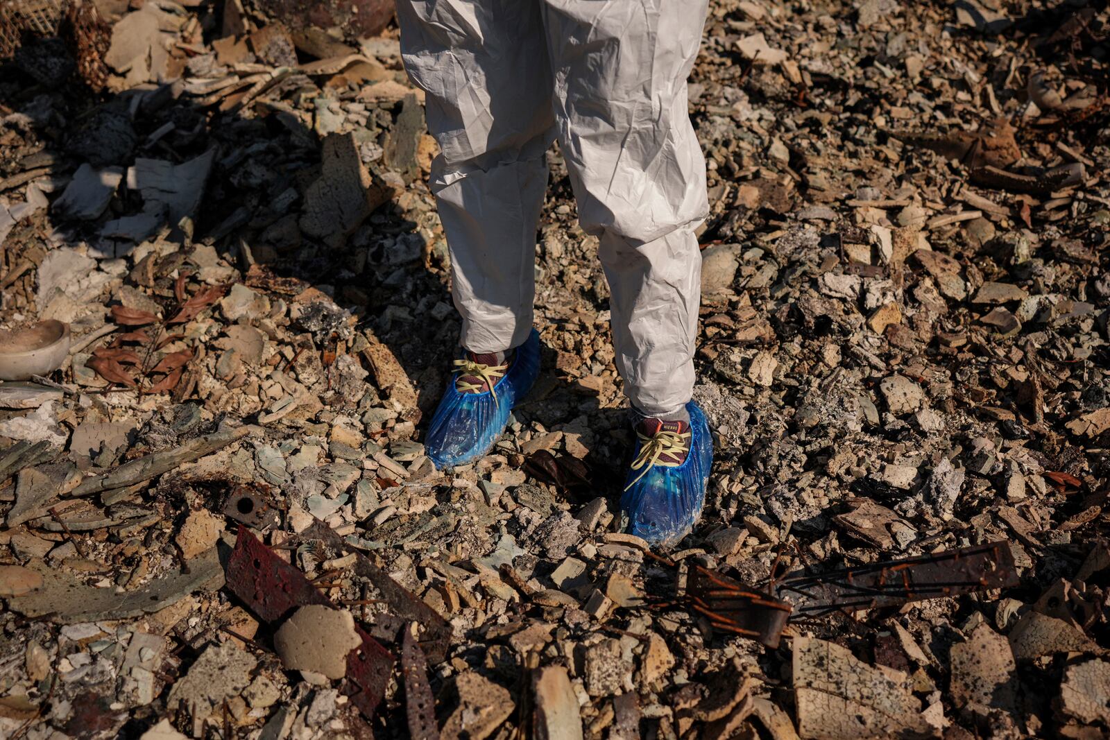 Liz Zaret searches for salvageable items in what remains of her home destroyed by the Palisades Fire in the Pacific Palisades neighborhood of Los Angeles, Tuesday, Jan. 28, 2025. (AP Photo/Jae C. Hong)