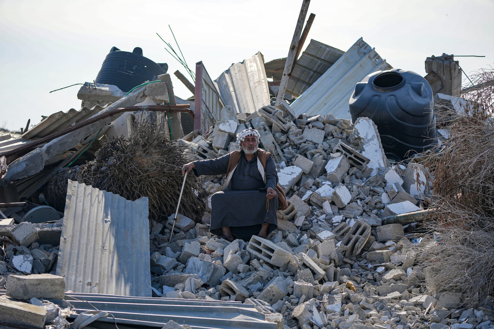 Atiya Abu Sheiban sits on the ruins of his destroyed home, days after the ceasefire deal between Israel and Hamas, in Rafah, southern Gaza Strip, Tuesday, Jan. 21, 2025. (AP Photo/Abdel Kareem Hana)