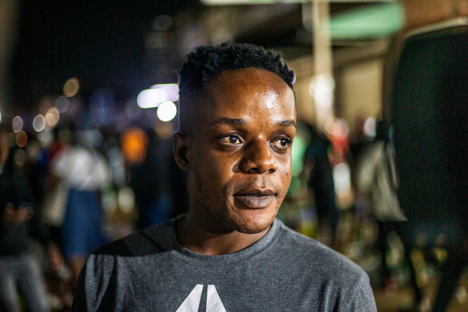 Batsirayi Pabwe shops at an informal and illegal markets that pop up at night to avoid police raids in central Harare, Zimbabwe, Friday, Nov. 11, 2024. (AP Photo/Aaron Ufumeli)