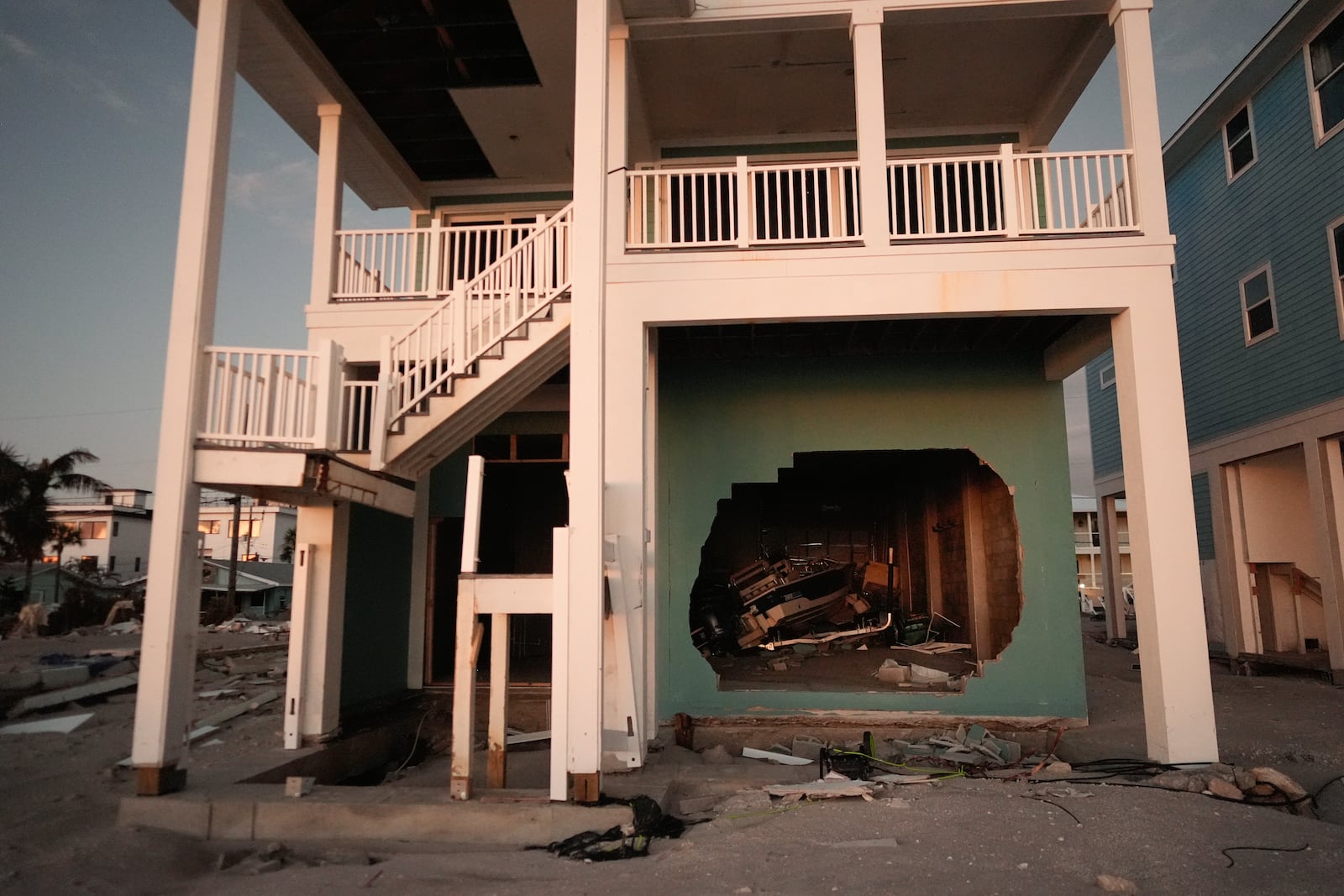 A boat is seen through a broken wall on the ground floor of a stilted home on Manasota Key, Fla., following the passage of Hurricane Milton, Saturday, Oct. 12, 2024. (AP Photo/Rebecca Blackwell)