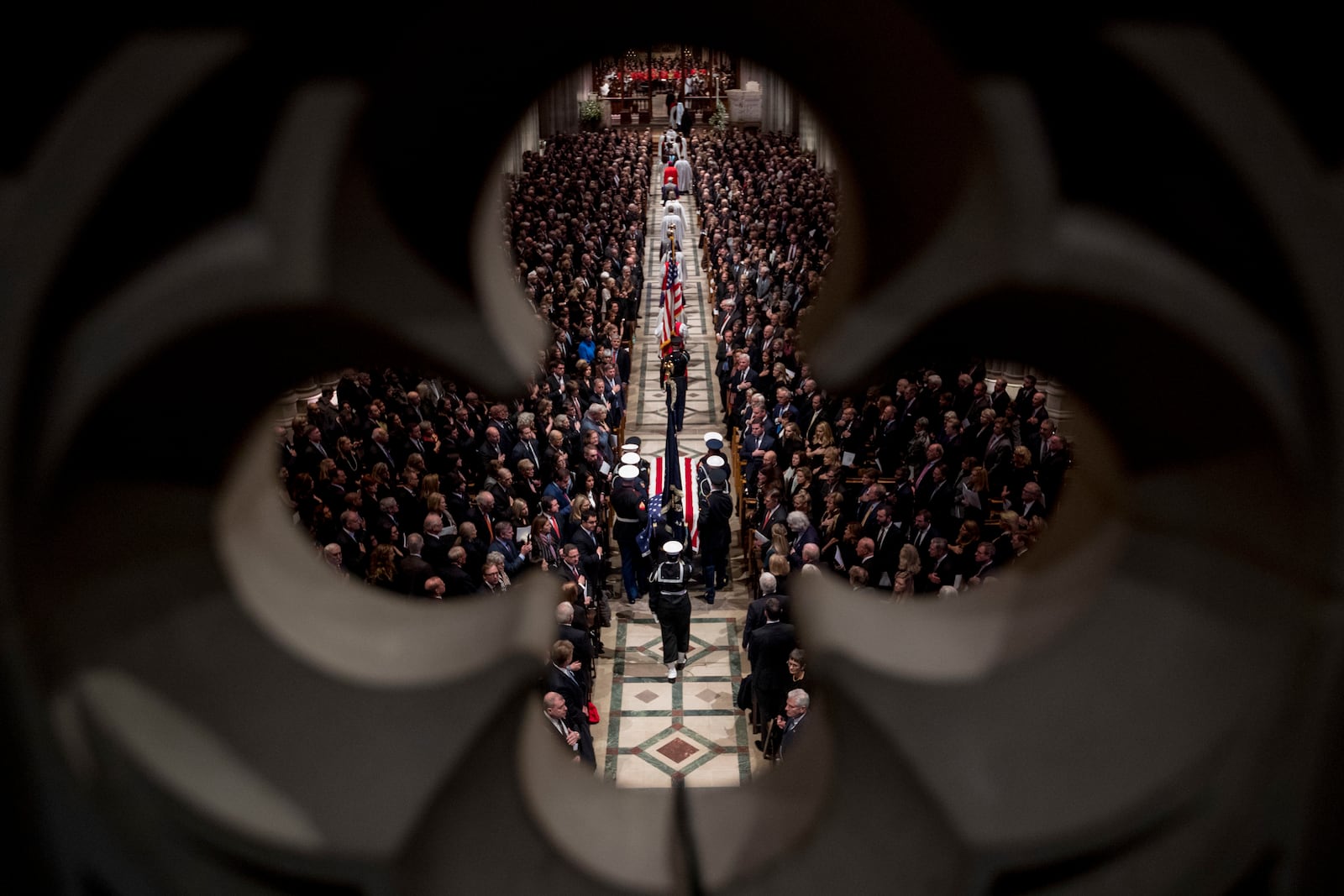 FILE - The flag-draped casket of former President George H.W. Bush is carried by a military honor guard into a State Funeral at the National Cathedral, Dec. 5, 2018, in Washington. (AP Photo/Andrew Harnik, Pool, File)