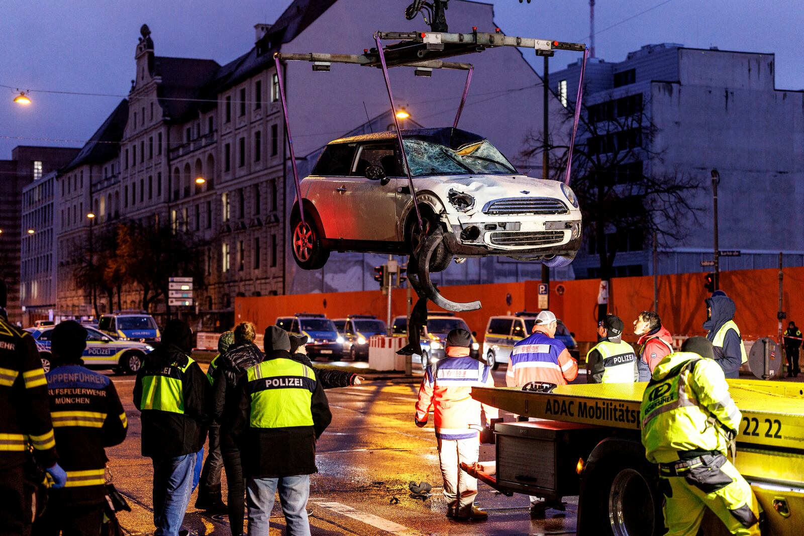 A car is lifted onto a tow truck at the scene where a driver drove a car into a labor union demonstration in Munich, Germany, Thursday Feb. 13, 2025. (Matthias Balk/dpa via AP)