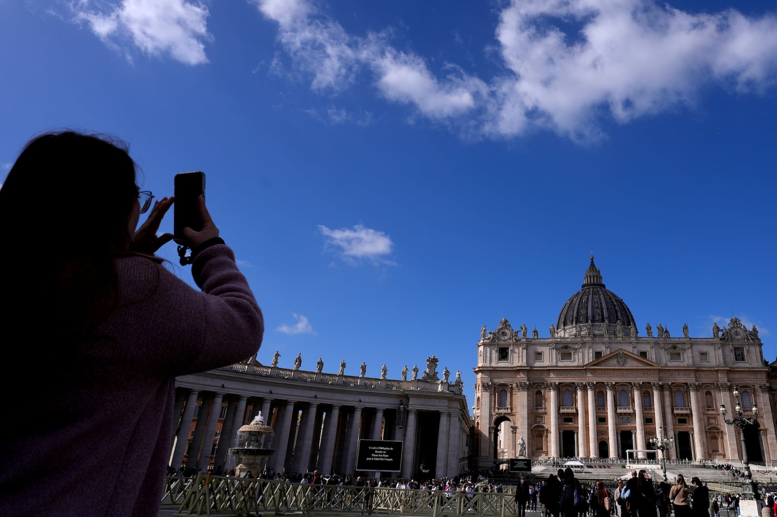 A woman takes pictures at St Peter's Square at The Vatican, Thursday, Feb. 27, 2025. (AP Photo/Kirsty Wigglesworth)