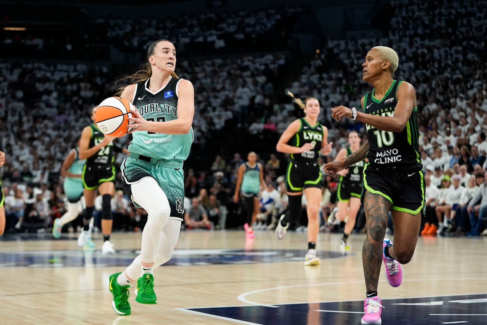 New York Liberty guard Sabrina Ionescu (20) drives to the basket towards Minnesota Lynx guard Courtney Williams (10) during the first half of Game 4 of a WNBA basketball final playoff series, Friday, Oct. 18, 2024, in Minneapolis. (AP Photo/Abbie Parr)