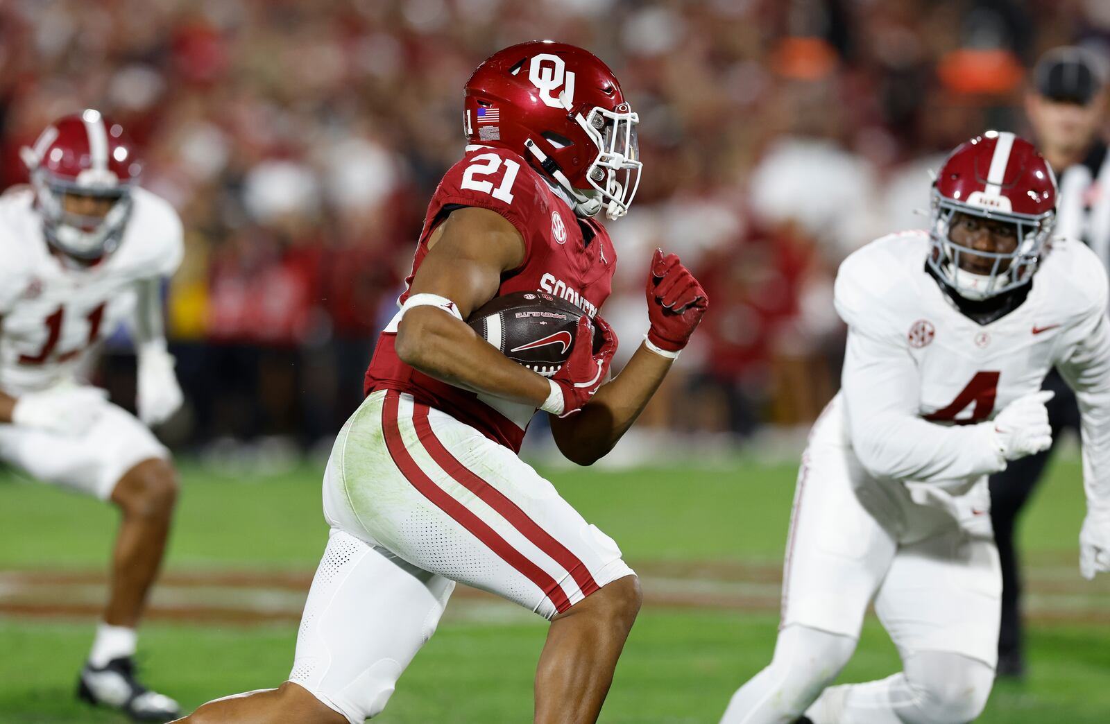 Oklahoma running back Xavier Robinson (21) runs the ball for a first down against Alabama during the second quarter of a NCAA college football game Saturday, Nov. 23, 2024, in Norman, Okla. (AP Photo/Alonzo Adams)