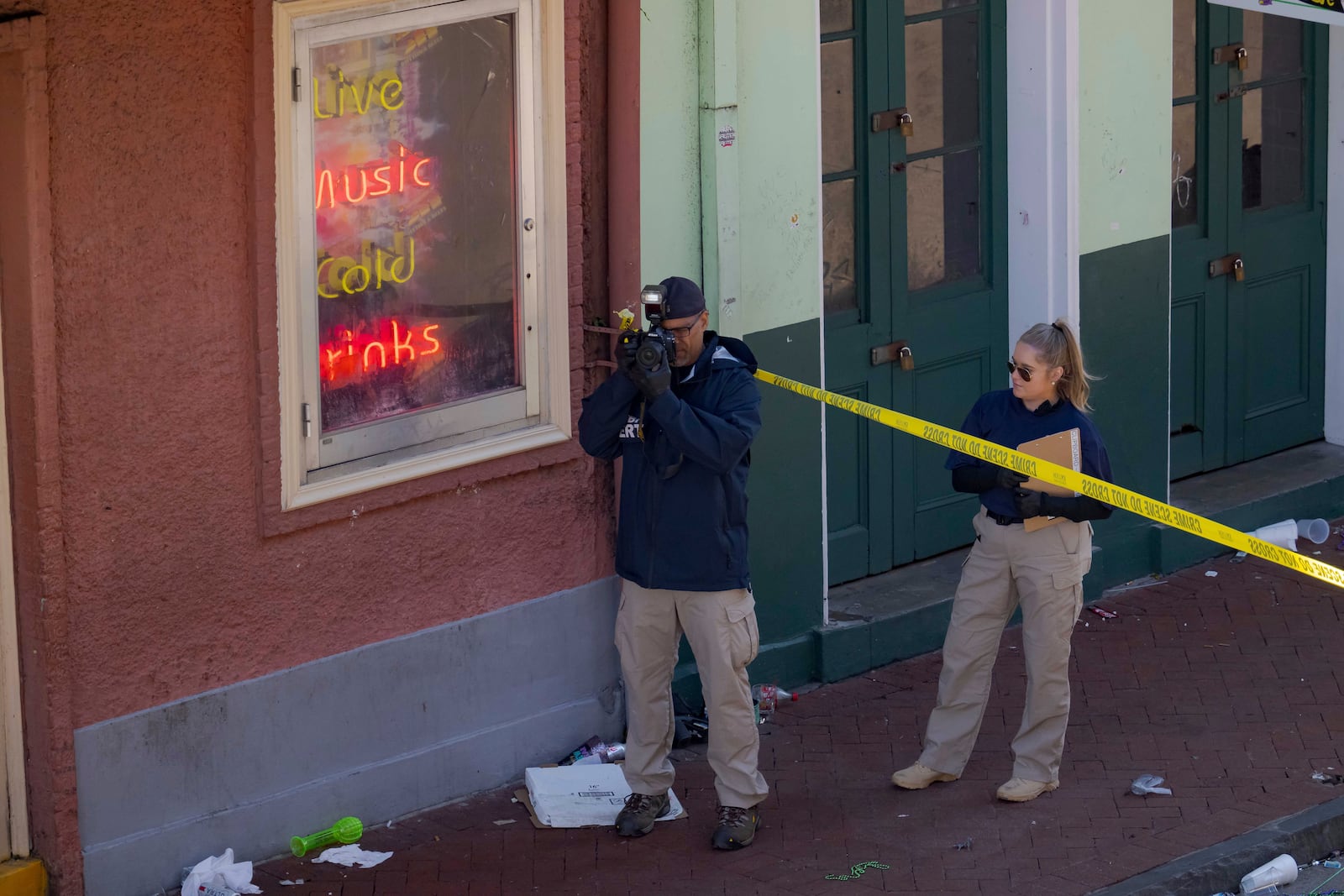 FBI members examine the scene on Bourbon Street during the investigation of a truck fatally crashing into pedestrians on Bourbon Street in the French Quarter in New Orleans, Wednesday, Jan. 1, 2025. (AP Photo/Matthew Hinton)