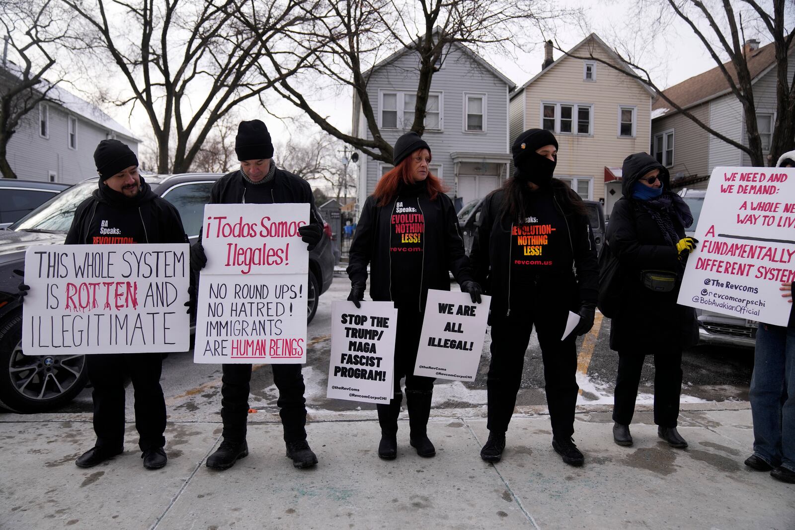 FILE - Activists with Revcom Corps Chicago hold signs outside of Hamline Elementary School after federal agents were turned away on Jan. 24, 2025, in Chicago. (AP Photo/Erin Hooley, file)