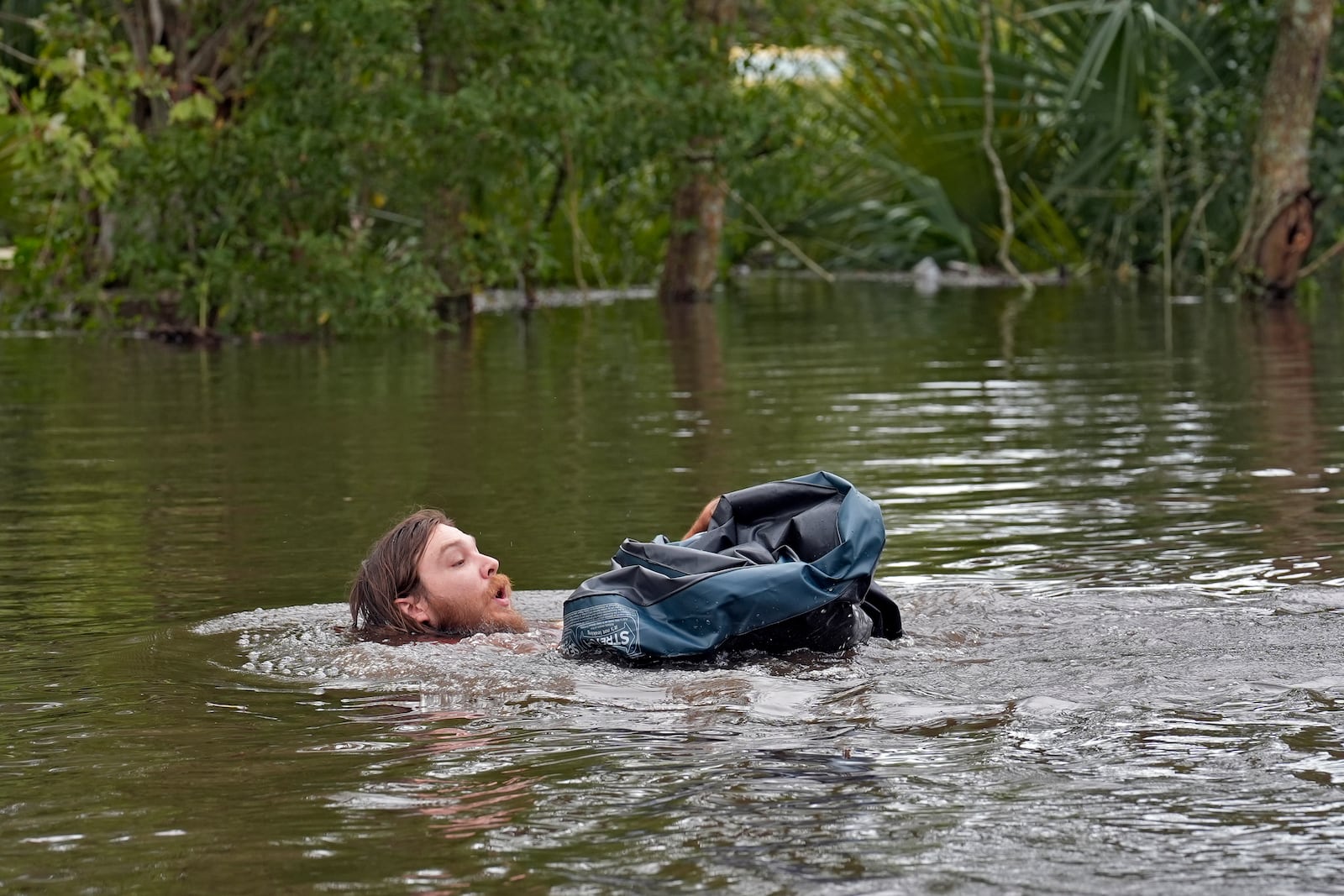 Connor Hughes of Lithia, Fla., moves in deep floodwaters from Hurricane Milton along the Alafia river Friday, Oct. 11, 2024, in Lithia, Fla. (AP Photo/Chris O'Meara)