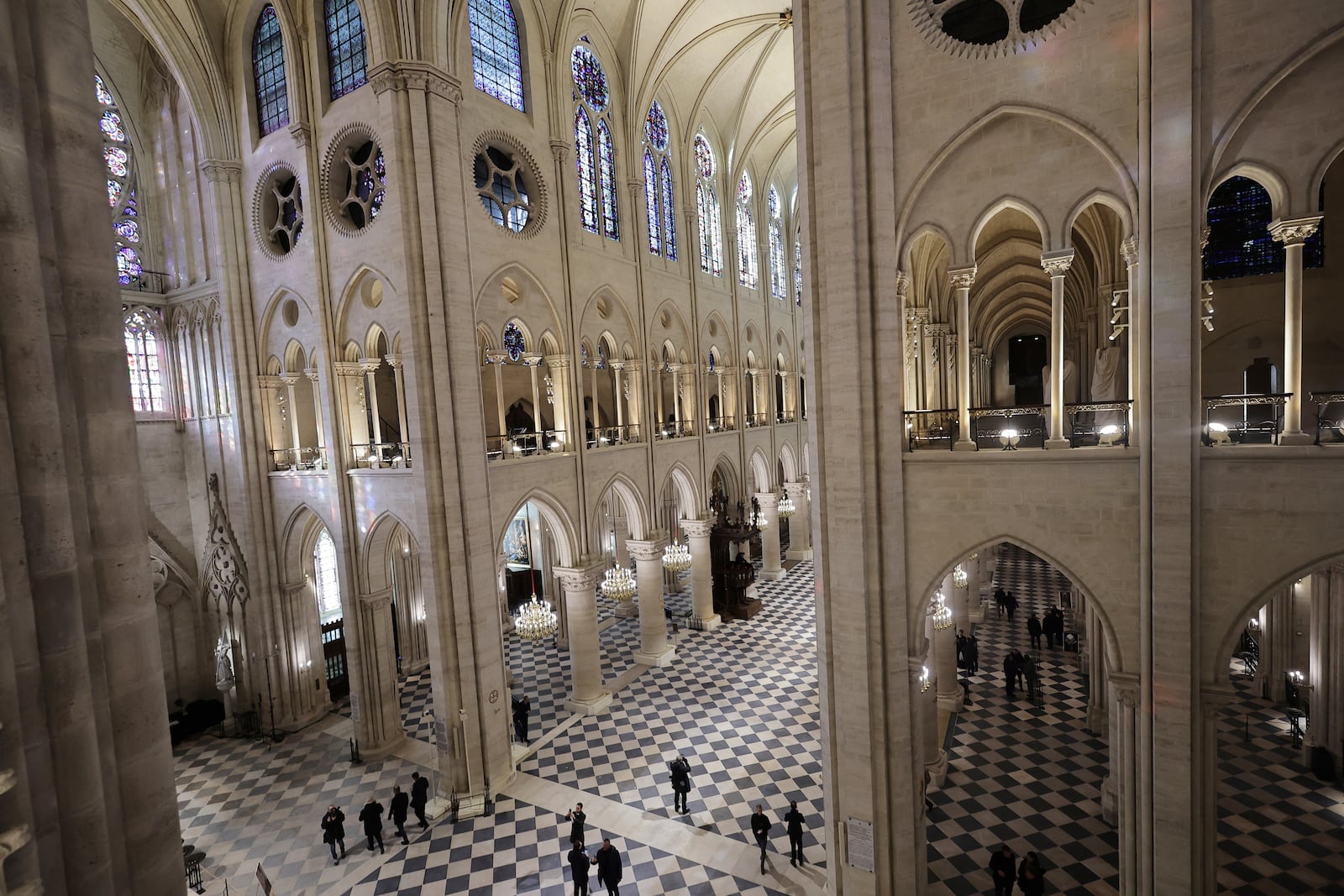 People stroll in Notre-Dame de Paris cathedral while French President Emmanuel Macron visits the restored interiors the monument, Friday, Nov.29, 2024 in Paris. (Christophe Petit Tesson, Pool via AP)