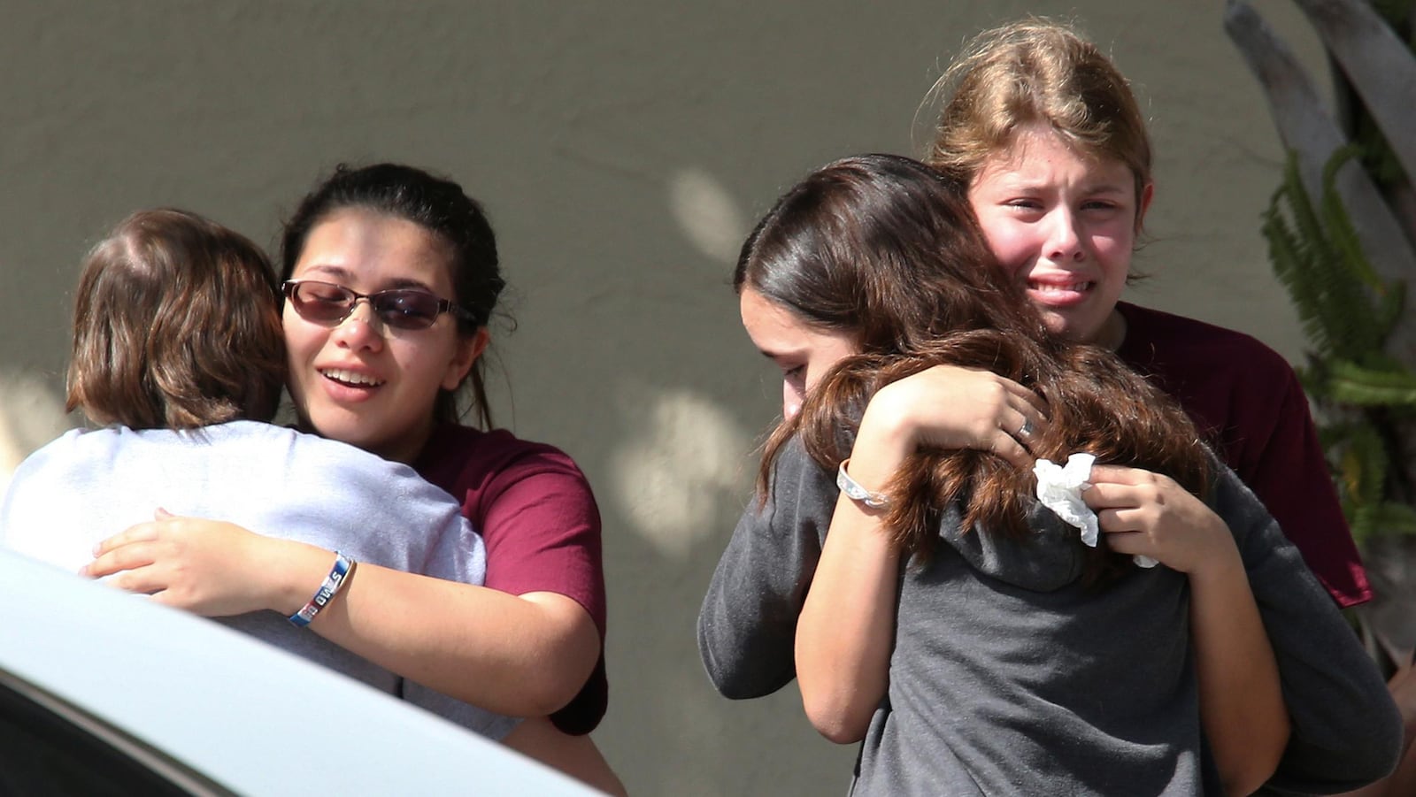 Students grieve outside Pines Trail Center where counselors are present, after Wednesday's mass shooting at Marjory Stoneman Douglas High School in Parkland, Fla., Thursday, Feb. 15, 2018.  Nikolas Cruz was charged with 17 counts of premeditated murder Thursday morning.  (AP Photo/Joel Auerbach)