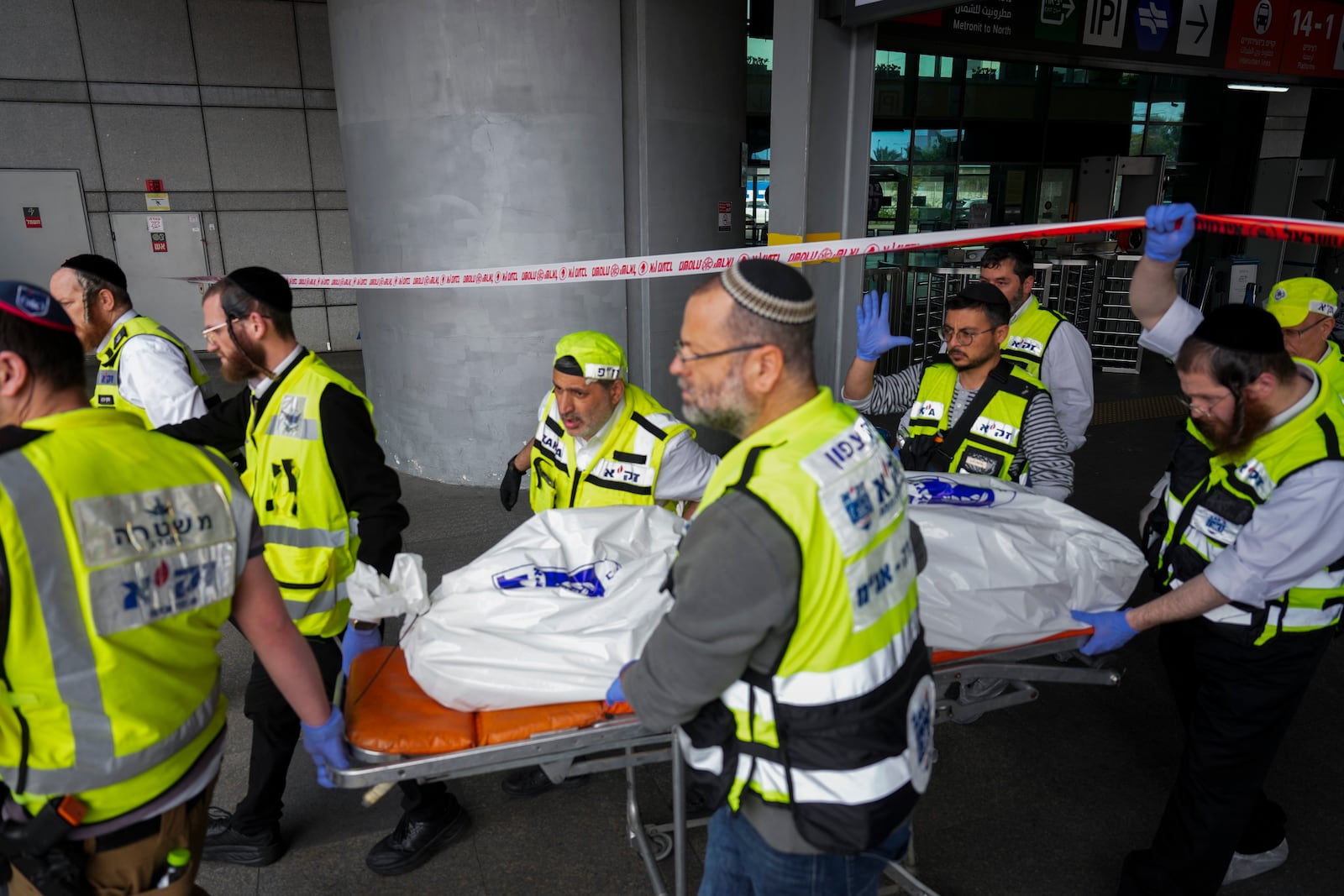 Members of ZAKA rescue services carry the body of a 70-year-old killed in stabbing attack in Haifa, Israel, on Monday, March 30, 2025. Four others were also injured in the incident. (AP Photo/Ariel Schalit)