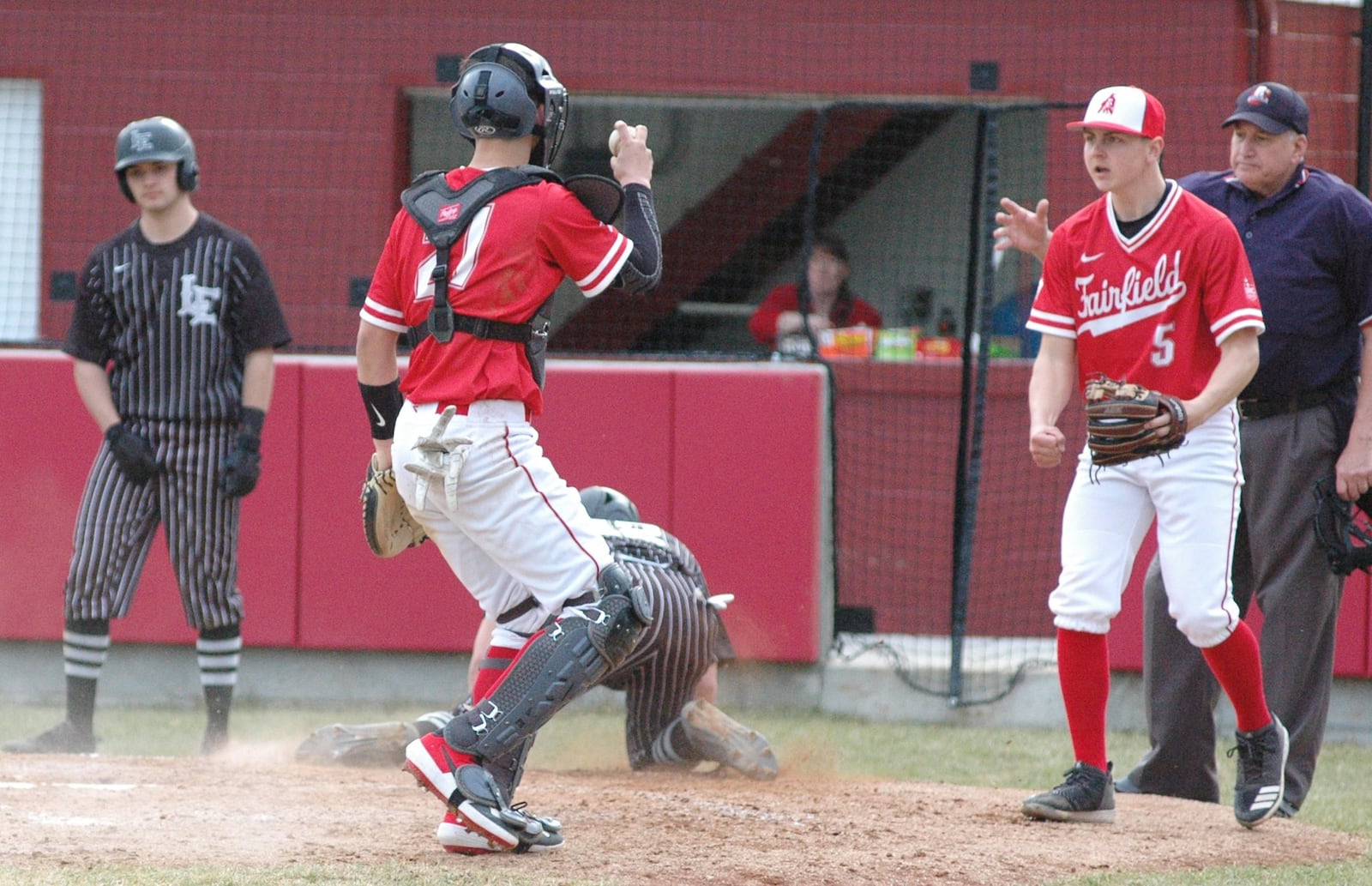 Fairfield catcher Caleb Schram shows the ball as pitcher Dylan Beal reacts on the play that nailed Lakota East’s Christian Bodden at home plate Wednesday. East won the Greater Miami Conference baseball game 2-1 at Joe Nuxhall Field in Fairfield. RICK CASSANO/STAFF