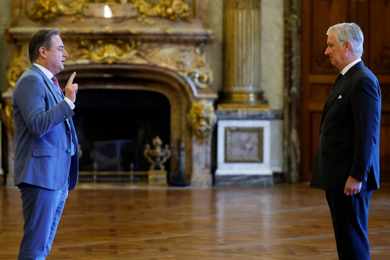 New Belgian Prime Minister Bart De Wever, left, raises his hand to take an oath during a swearing in ceremony for the new government in front of Belgium's King Philippe at the Royal Palace in Brussels, Monday, Feb. 3, 2025. (AP Photo/Omar Havana)