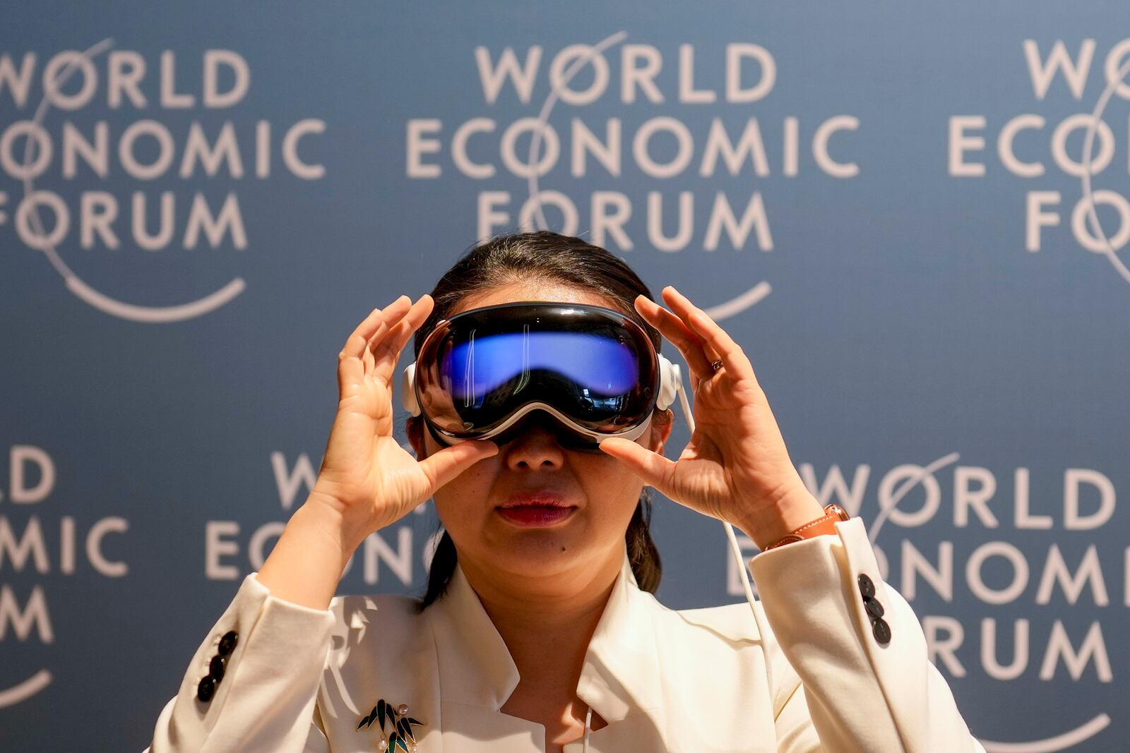 A woman uses virtual reality glasses the Annual Meeting of World Economic Forum in Davos, Switzerland, Wednesday, Jan. 22, 2025. (AP Photo/Markus Schreiber)