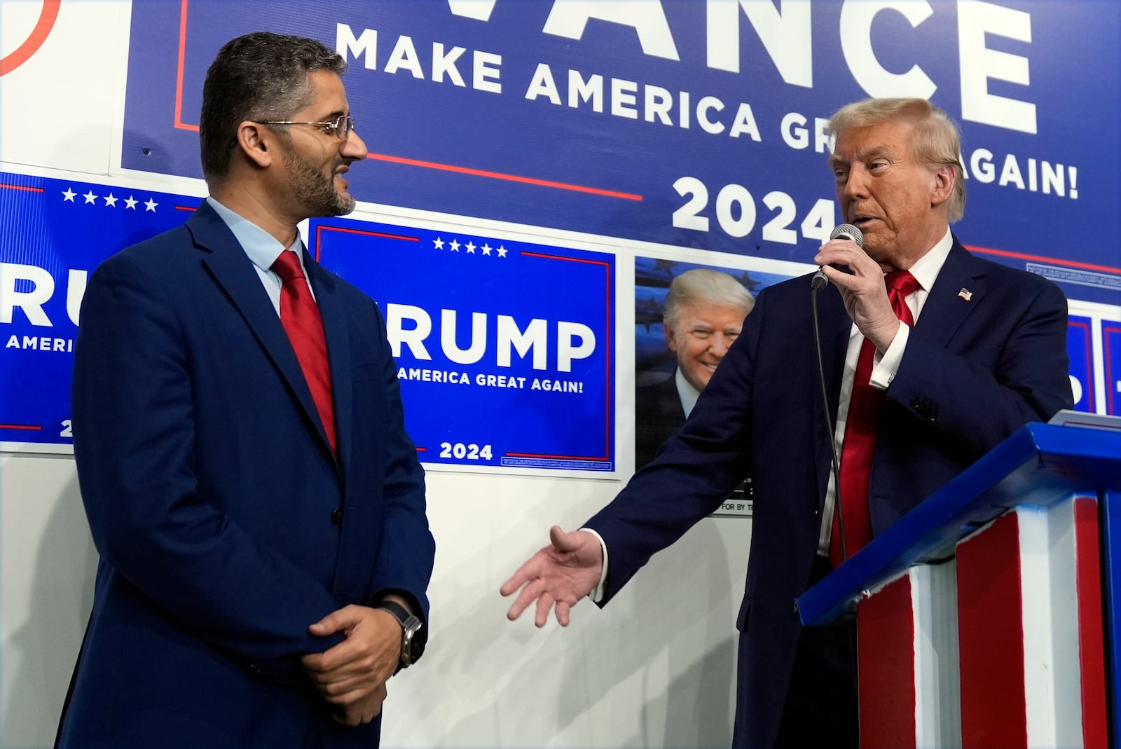 Republican presidential nominee former President Donald Trump speaks as Hamtranck Mayor Amer Ghalib listens at a campaign office, Friday, Oct. 18, 2024, in Hamtranck, Mich. (AP Photo/Evan Vucci)