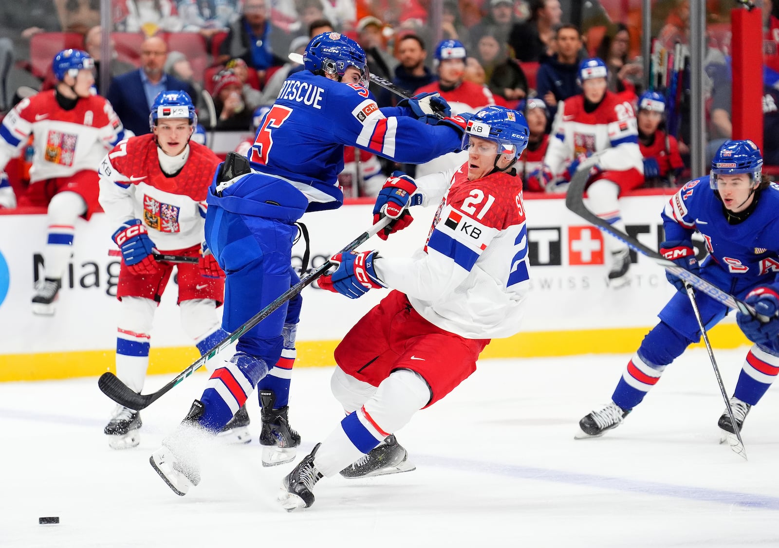 United States defenseman Drew Fortescue (5) checks Czechia forward Jakub Stancl (21) during second-period World Junior hockey championship semifinal game action in Ottawa, Ontario, Saturday, Jan. 4, 2025. (Sean Kilpatrick/The Canadian Press via AP)