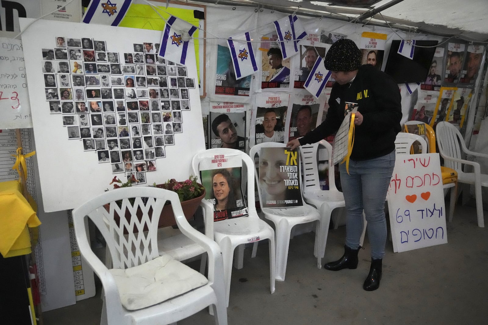 A poster shows Shiri Bibas, center, who was kidnapped to Gaza with her husband and two young sons on Oct. 7, 2023, in Jerusalem, Friday, Feb. 21, 2025. (AP Photo/Mahmoud Illean)