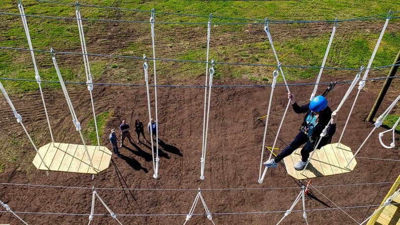 Patricia Dawson, public relations coordinator for Butler County Board of Developmental Disabilities, climbs on the Great Miami Valley YMCA's high ropes course now open at Camp Campbell Gard Wednesday, May 15, 2019 on Augspurger Road in St. Clair Township. The course stands nearly fifty feet tall with three levels of elements ranging in difficulty. There is also a climbing wall, zip line, giant swing and more. The course has a universal access system allowing participants with all abilities, including those in wheel chairs, the opportunity to experience it. NICK GRAHAM/STAFF