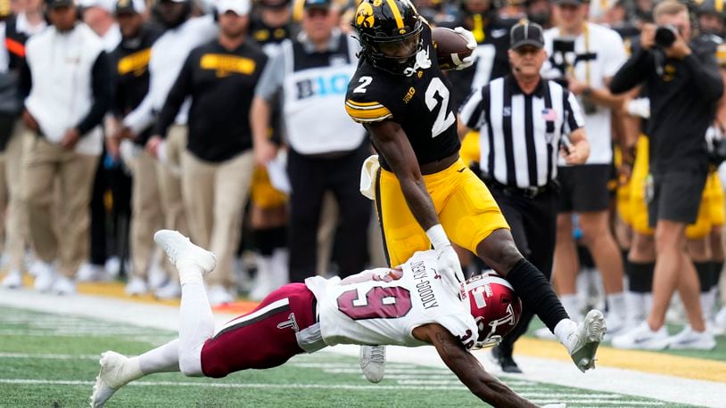 Iowa running back Kaleb Johnson (2) tries to break a tackle by Troy safety Ian Conerly-Goodly (39) during the first half of an NCAA college football game, Saturday, Sept. 14, 2024, in Iowa City, Iowa. (AP Photo/Charlie Neibergall)