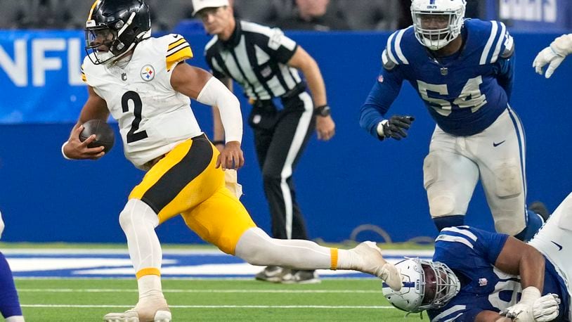 Pittsburgh Steelers quarterback Justin Fields (2) scrambles past a tackle-attempt by Indianapolis Colts defensive end Tyquan Lewis, lower right, during the second half of an NFL football game Sunday, Sept. 29, 2024, in Indianapolis. (AP Photo/Darron Cummings)