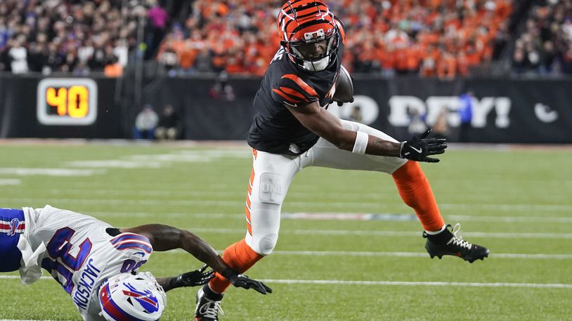 Cincinnati Bengals wide receiver Ja'Marr Chase, right, tries to dodge a tackle attempt by Buffalo Bills cornerback Dane Jackson during the first half of an NFL football game, Sunday, Nov. 5, 2023, in Cincinnati. (AP Photo/Darron Cummings)