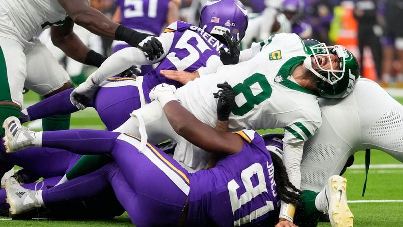 New York Jets quarterback Aaron Rodgers (8), right, reacts as he is tackled during the second half of an NFL football game against the Minnesota Vikings, Sunday, Oct. 6, 2024, at the Tottenham Hotspur stadium in London. (AP Photo/Kirsty Wigglesworth)