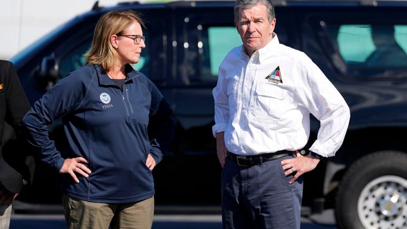 FILE- North Carolina Gov. Roy Cooper, right, and Deanne Criswell, Administrator of the U.S. Federal Emergency Management Agency, await the arrival of Democratic presidential nominee Vice President Kamala Harris for a briefing on the damage from Hurricane Helene, at Charlotte Douglas International Airport, Oct. 5, 2024, in Charlotte, N.C. (AP Photo/Chris Carlson, file)