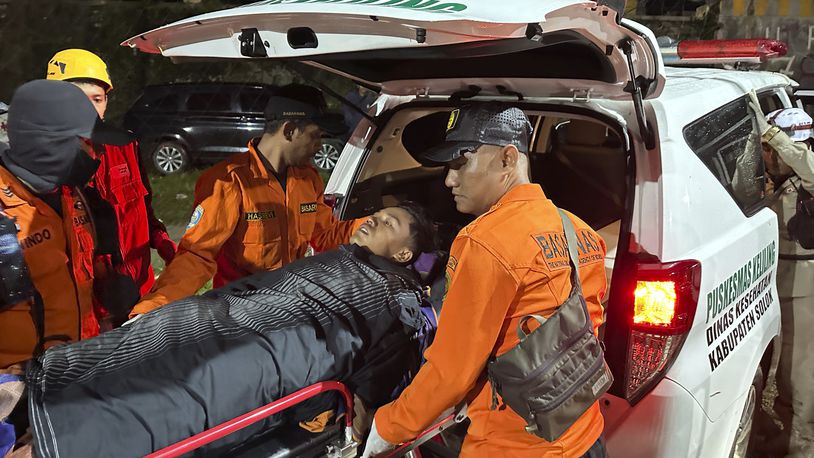 Rescuers transfer a survivor into an ambulance after a landslide set off by torrential rains smashed down into an unauthorized gold mining operation, killing several people, in Solok, West Sumatra, Indonesia, Saturday, Sept. 28, 2024. (AP Photo/John Nedy)